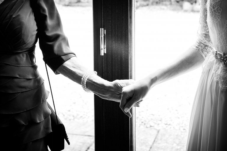 Grandmother holding bride's hand