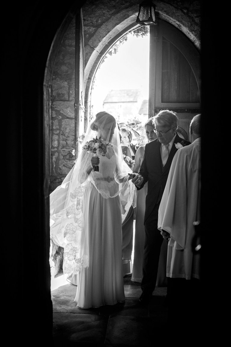 bride and father in church doorway