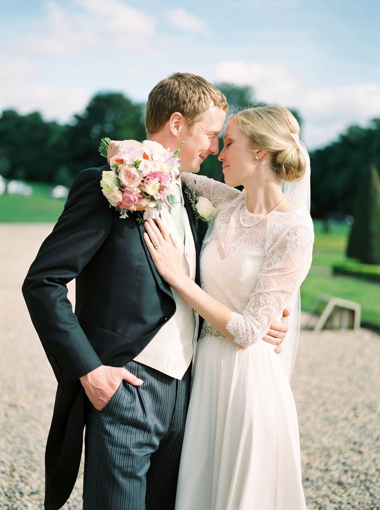 bride with arms around groom neck