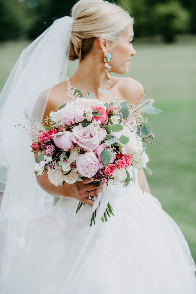 bride holding bouquet of pink peonies
